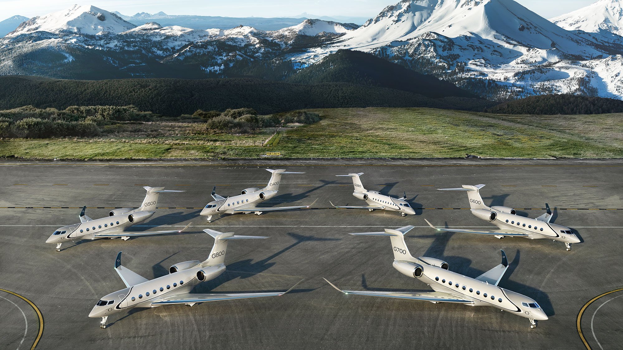 Six Gulfstream business jets, including G500, G600, G700, and G800 models, parked on a runway with snow-covered mountains in the background.