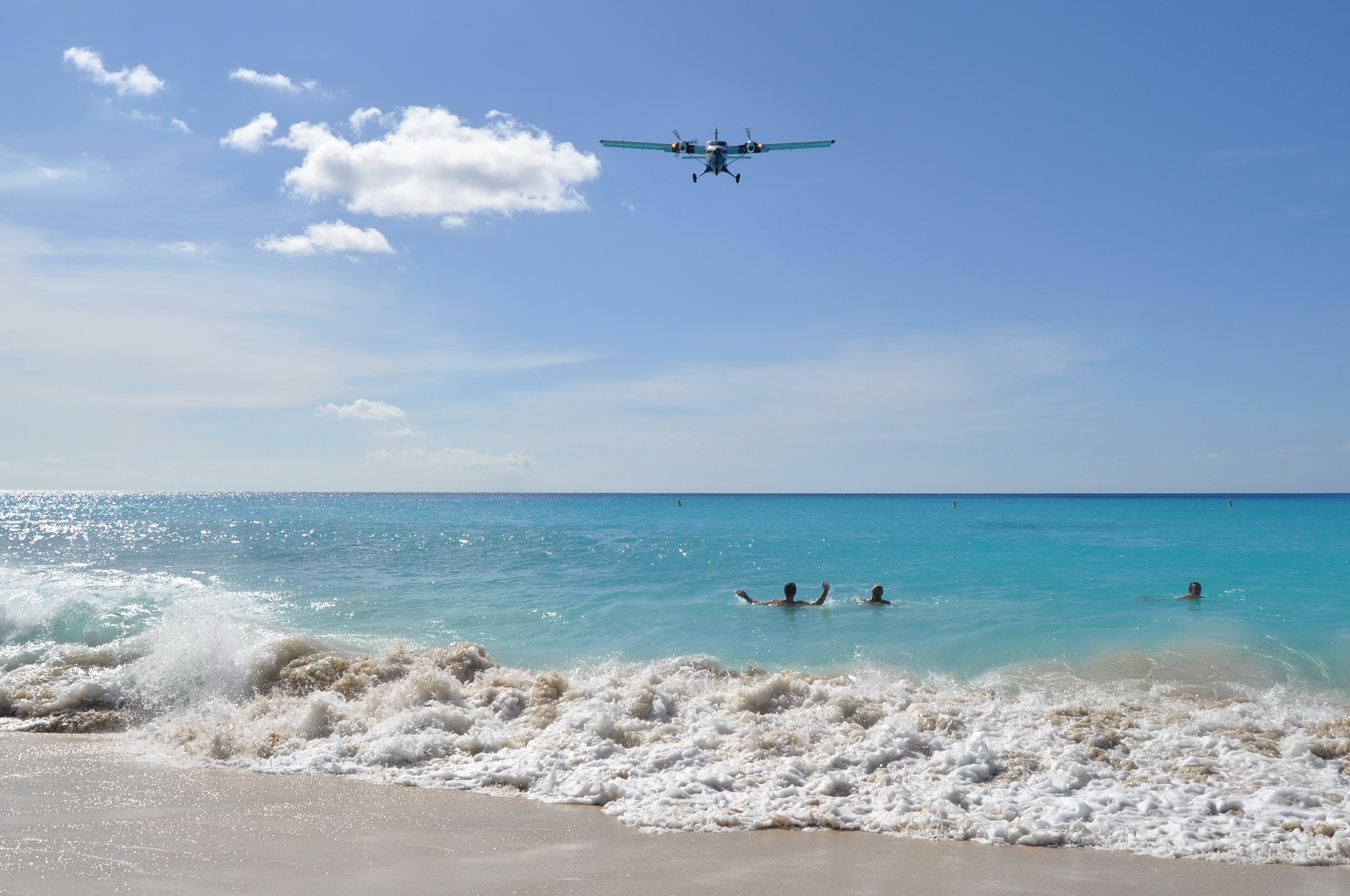 Aircraft approaching Princess Juliana Airport low over Maho Beach swimmers in St. Maarten.