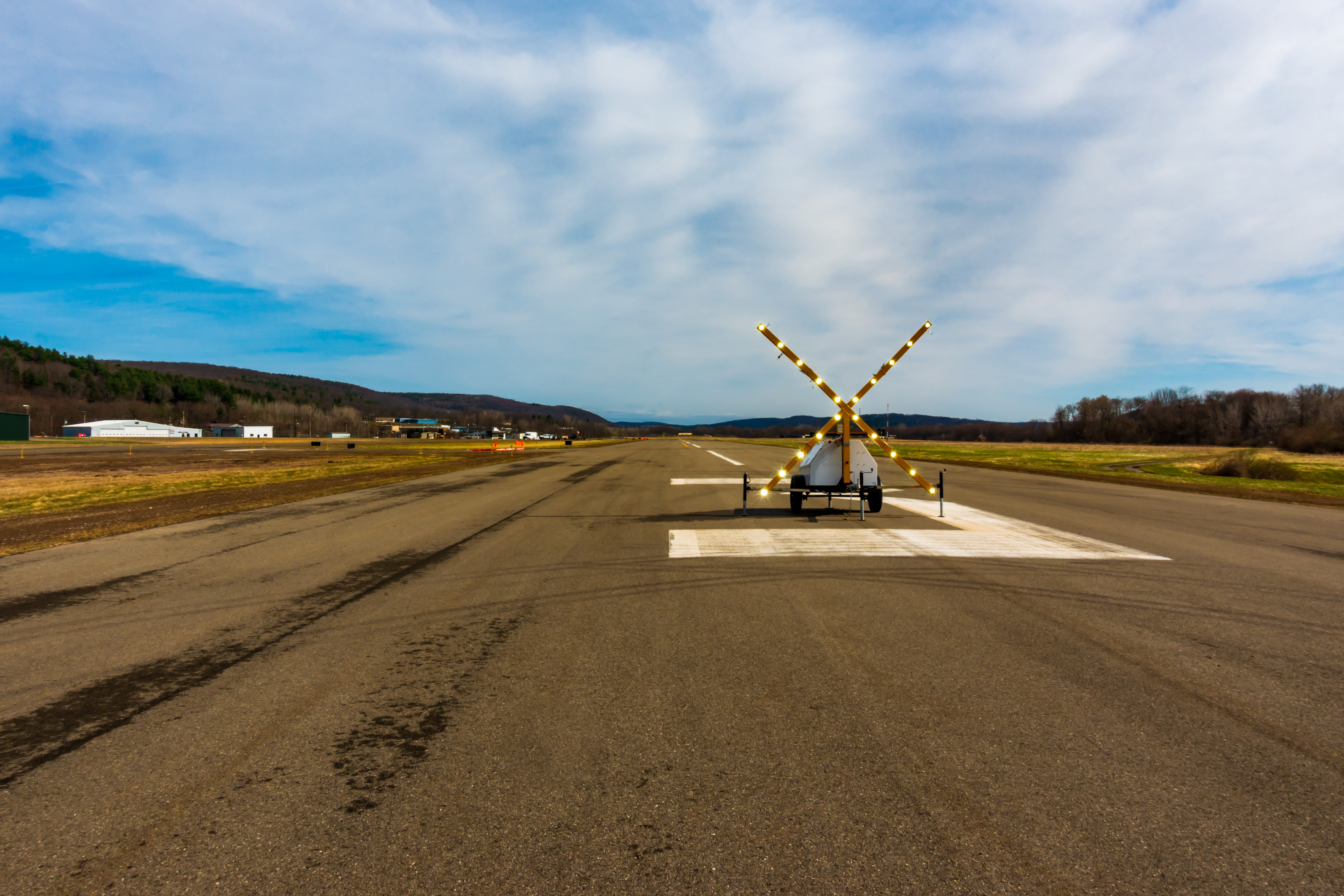 Temporary runway closure with portable illuminated “X” barrier at a general aviation airport, indicating NOTAM in effect. Used for pilot awareness and flight planning safety.